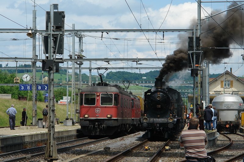 125 Jahre Gotthardbahn - Whrend auf Geleis 1 der Jubilumszug auf seine Weiterfahrt wartet, rauscht auf dem Nebengeleis noch ein Gterzug vorbei. Ob deren Lokfhrer lieber auf der A 3/5 (705) wre ?? Ich weiss es leider nicht. Bhf. Frick (Aargau) am 31.5.2007.