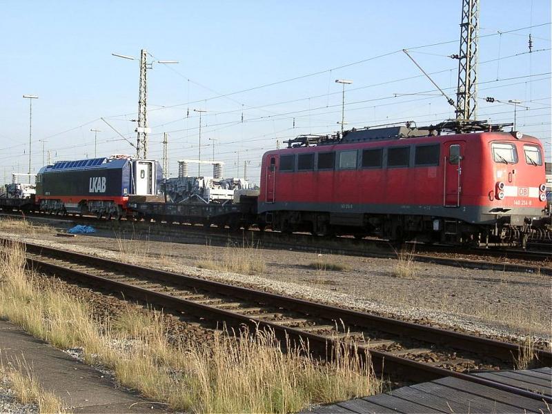 140 214 - 8 hat eine Hlfte der IORE 110 fr die LAKB gerad nach Maschen gebracht. Vor und hinter der Lok laufen bergwangswagen, auf denen Drehgestelle gelagert werden.