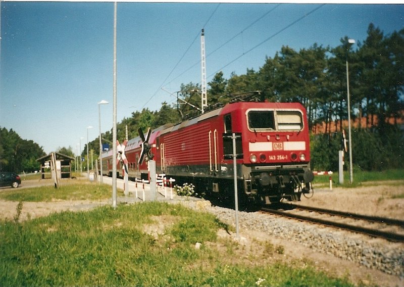 143 254 mit der Regionalbahn nach Binz am Haltepunkt Prora-Ost im Mai 2001.Fr manch Einen war dieser Haltepunkt der Beginn oder das Ende seiner Armeezeit.Wenige Meter vom Haltepunkt befand sich der Eingang zu einer NVA-Kaserne.