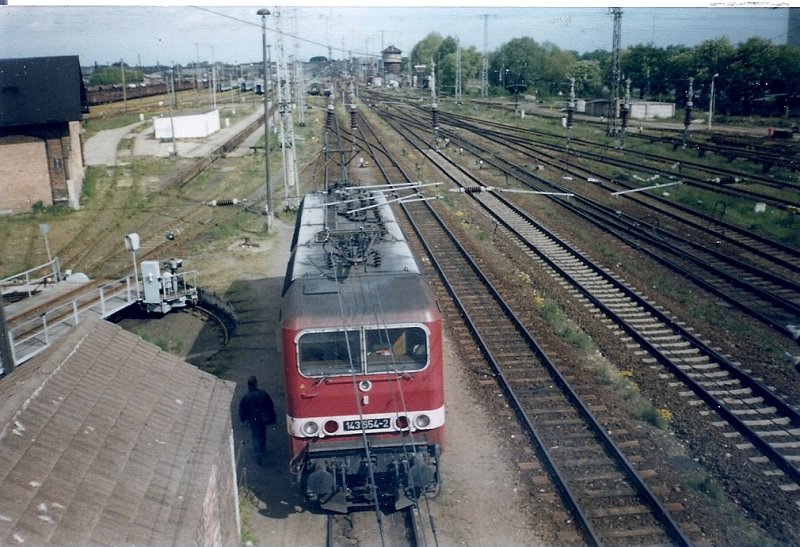 143 654 kommt im Mai 1997 von ihrem Zug ins Bw Stralsund gefahren.Die Ablsung fr den Lokfhrer ist auch schon da!
