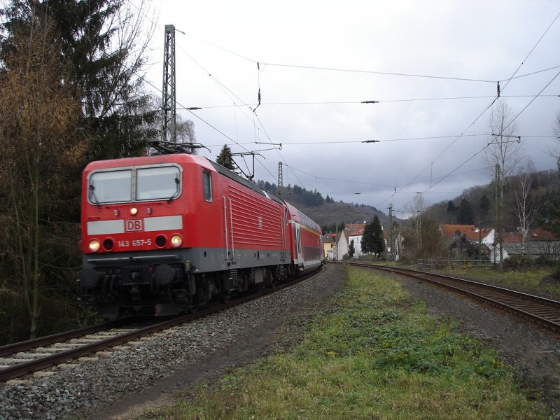 143 657-5 kommt bei Lorsbach mit einem Regionalzug aus Limburg(Lahn) nach Frankfurt(M) Hbf um die Ecke geschossen.