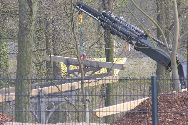 14.4.2005 Potsdam Park Sanssouci. Im Umfeld des Kaiserbahnhofs wird ein historisches Bahnsteigdach am Fue des Bahndammes regelrecht im Wald errichtet. Hier hebt ein ADK gerade ein Segment ein. Vermutlich entsteht hier die  Pausenecke fr Bahnmanager 