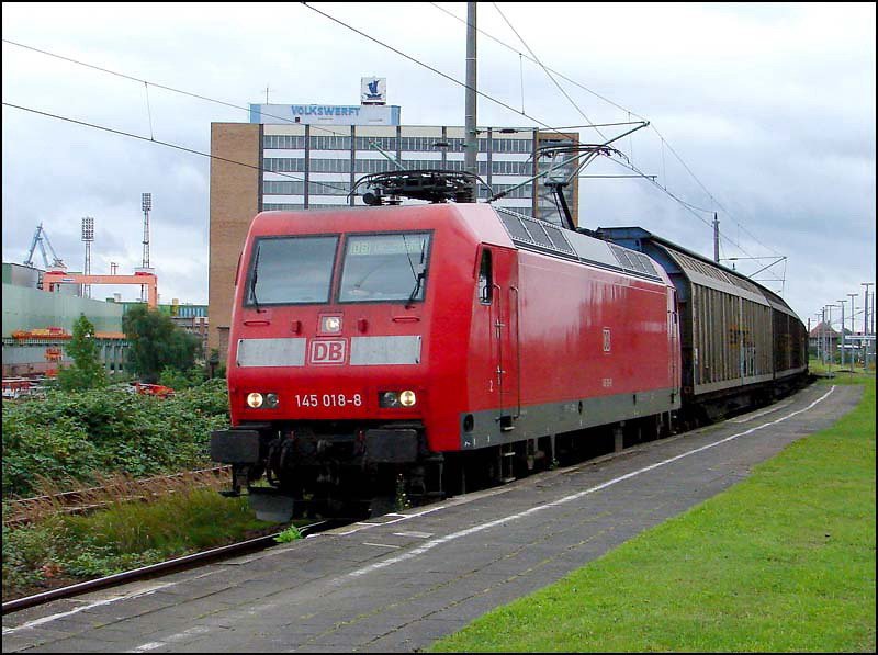 145 018-8 durchfhrt mit einem Gterzug den Bhf Stralsund - Rgendamm.  (am 12.08.05) 