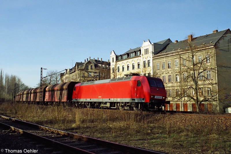 145 051 bringt an einem Aprilmorgen 2005 den Kohleleerzug von Chemnitz/Siegmar nach Hbf. Hier vor der Kulisse der Huser an der Chemnitzer Rembrandtstrae.