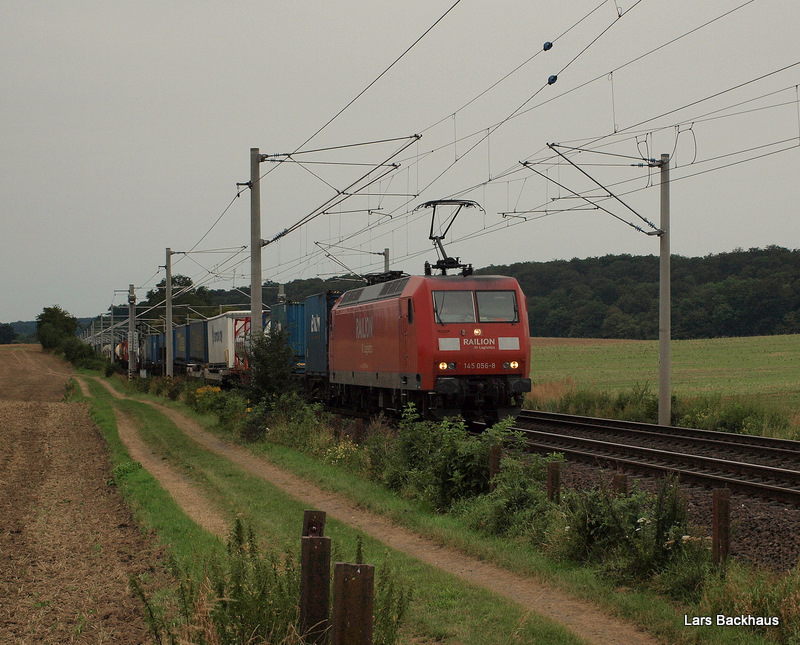 145 056-8 poltert am Morgen des 15.08.09 einem Kombizug nach Lbeck-Skandinavien durch die weite Feldlandschaft vor Reinfeld (Holst.) Richtung Lbeck.