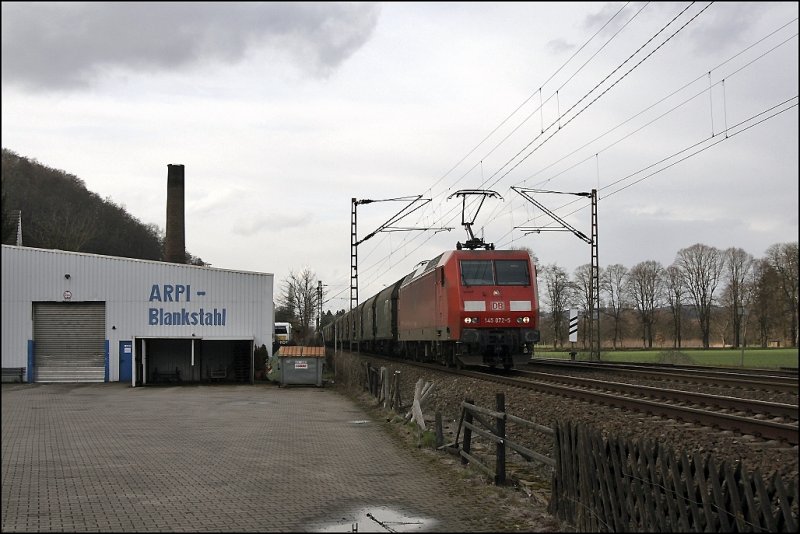 145 072 ist mit einem Coilzug, bestehend aus Waggons der B-CARGO, bei Hohenlimburg in Richtung Siegen unterwegs. (27.03.2009)
