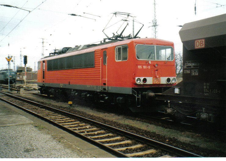 155 191-0 mit Güterzug am Bahnsteig 2 in Falkenberg/Elster unterer Bahnhof. Die offene vordere Tür hat weniger mit den extremen Außentemperaturen zu tun, sondern mit einem Lokführerwechsel. Aufnahme: ca. Juni-Juli 2004