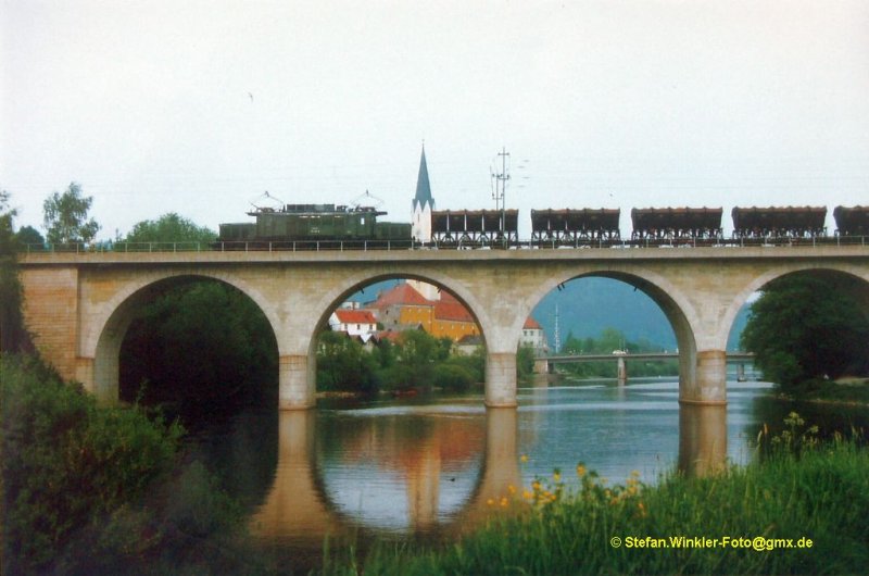17.Mai 1985. Die 194569 berquert mit einem Schotterganzzug aus Muldenkippern die Vilsbrcke in Vilshofen. Schne Aufnahme aus meinem Dia-Archiv (ber abfotogr. Abzug).