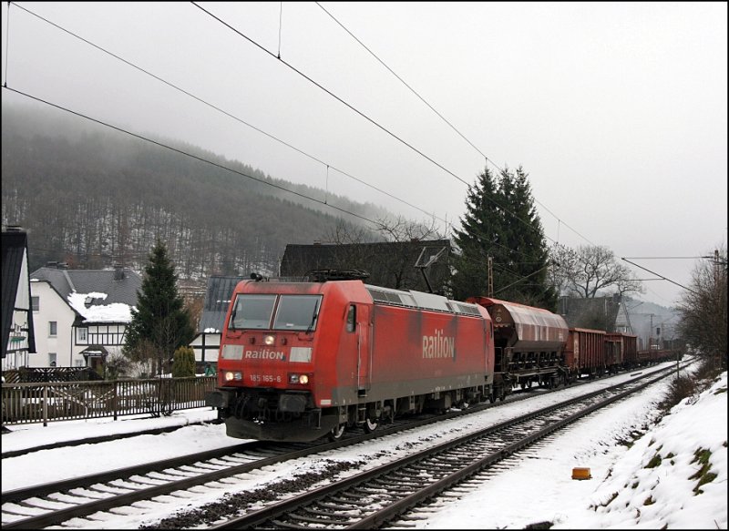 185 165 schleppt einen langen Gterzug die Steigung hinauf nach Welschen-Ennest....
