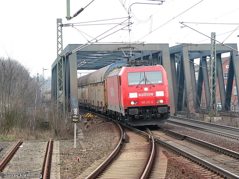 185 211 berquert mit einem Car Rail Logistic Zug die Allerbrcke am Bahnhof Celle und ist auf dem Weg in Richtung Sden. 