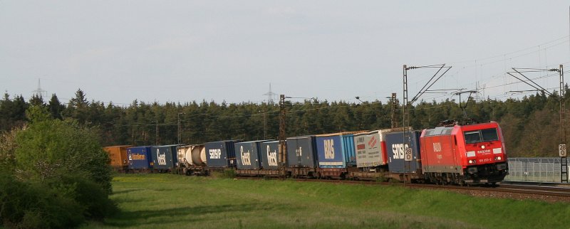 185 243 legt sich mit einem langen Containerzug am 25.04.2008 in den Bogen der KBS 700 zwischen Waghusel und Neuluheim.