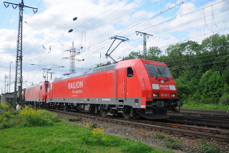 185 291-2 mit Railion-Logo in einer Doppeltraktion mit einer weiteren 185 mit DB-Logo vor einem Klv-Zug. (Gremberg, 18.05.2009).