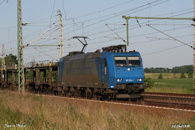 185 526-1 der HGK passiert Pillgram mit leeren Autotransportwagen