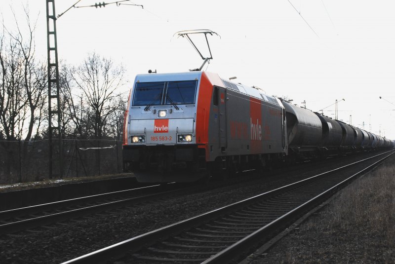 185 583-2 in schnem Orange/Silber der HVLE kommt aus Richtung Hamm und zieht Ihren Gterzug von ca. 40 Kesselwagen in Richtung Bielefeld. Die tiefstehende Sonne verhindert einen noch besseren Farbgeschmack. Nachmittag des 12.02.2009 an der Steigung zur Avenwedder Brcke.