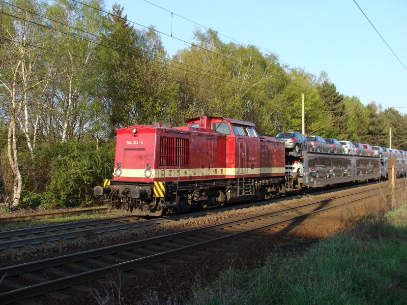 204 354-5 der Muldental Eisenbahnverkehrsgesellschaft (MTEG) fhrt mit einem langen Autozug in Richtung Braunschweig. Fotografiert am 13.04.2009 unter der Straenbrcke Diesdorfer Graseweg in Magdeburg.