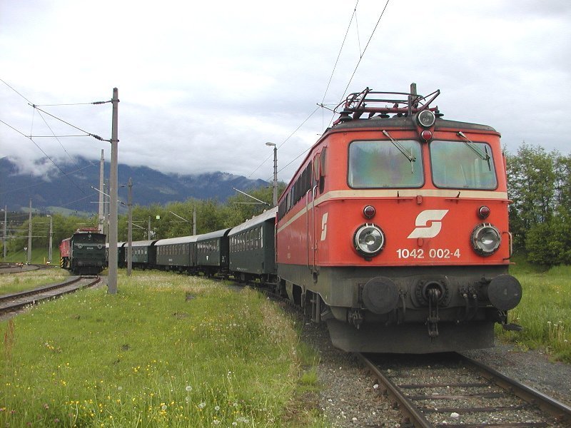 21.05.2006, 1042.002 mit den Nostalgiewagen des  Giselazuges  im Freigelnde der Zf Saalfelden, im Hintergrund die 1670.09 mit einem Klima-Schneepflug
