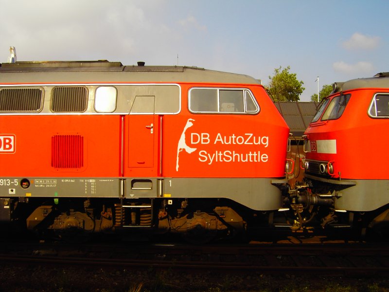 215 913-005 und eine weitere 215 sind gerade mit ihrem Autoreisezug aus Niebll in Westerland(Sylt) eingetroffen.
Beide Loks tragen ein Logo mit der Insel Sylt und dem Schriftzug: DB AutoZug Syltshuttle