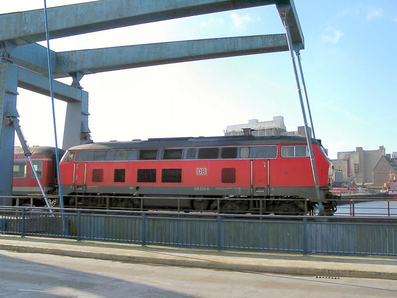 218 256 auf der Hubbrcke ber den Husumer Hafen. Die Lok schiebt einen RB in Richtung Heide (-Hamburg) und erreicht gleich den Husumer Bahnhof.