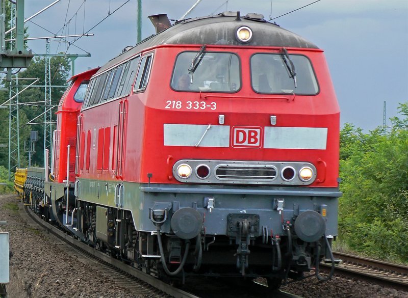 218-333-3 mit einer DB V100 und einem kleinen Gz. im Schlepp vor einem aufziehenden Gewitter , aufgenommen im Juli 09 in Porz Wahn an der Strecke.