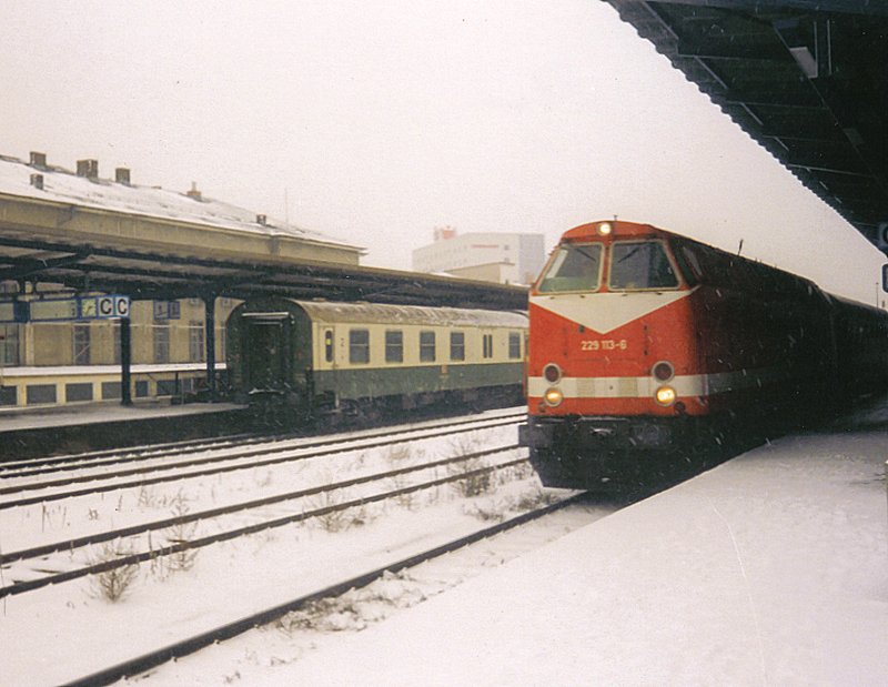 229 113-6 war eine von vier Maschinen mit der sogenannten  Wagnermtze . Diese Loks hatten das dritte Spitzenlicht ber den Fhrerstandsfenstern. Hier erreicht sie mit IR 2456 Chemnitz-Dsseldorf im Februar 1999 den Bahnhof Gera.
