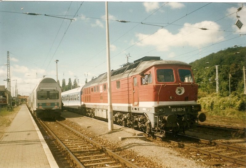 232 097 ist mit dem Kurswagen Malmö-Berlin in Sassnitz(Aufnahme aus dem Jahre 1997) angekommen.Nachdem die Regionalbahn ausgefahren ist kann die 232 den Kurswagen auf das dortige Gleis rangieren.
