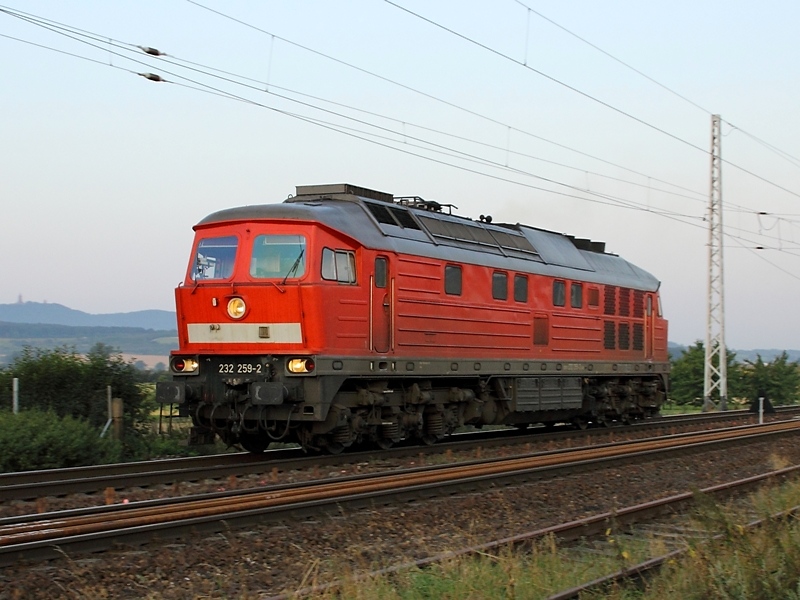 232 259-2 durchfhrt im Morgengrauen des 4.8.2009 den Bahnhof Wallhausen. Im Hintergrund ist der Kyffhuser zu sehen.