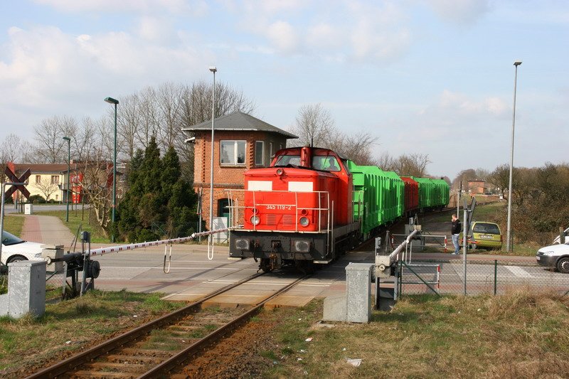 345 119 mit Holzzug fhrt in Hagenow Stadt am Stellwerk vorbei nach Hagenow Land.03/2007
