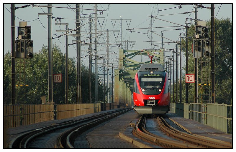 4124 013 als S 80 von Wien S�dbahnhof Ostseite nach Wien Hausfeldstra�e am 16.9.2007 bei der Querung der Neuen Donau in der Wiener Lobau. In Wien Hausfeldstra�e endet auch die Elektrifizierung. Die restliche Strecke nach Marchegg, respektive Bratislava ist eine reine Dieselstrecke, soll aber in den n�chsten Jahren elektrifiziert werden. Wie man (auf dem Bild zwar nicht) sehen kann, werden die Zweisystementen immer h�ufiger im normalen S-Bahnverkehr eingesetzt.

