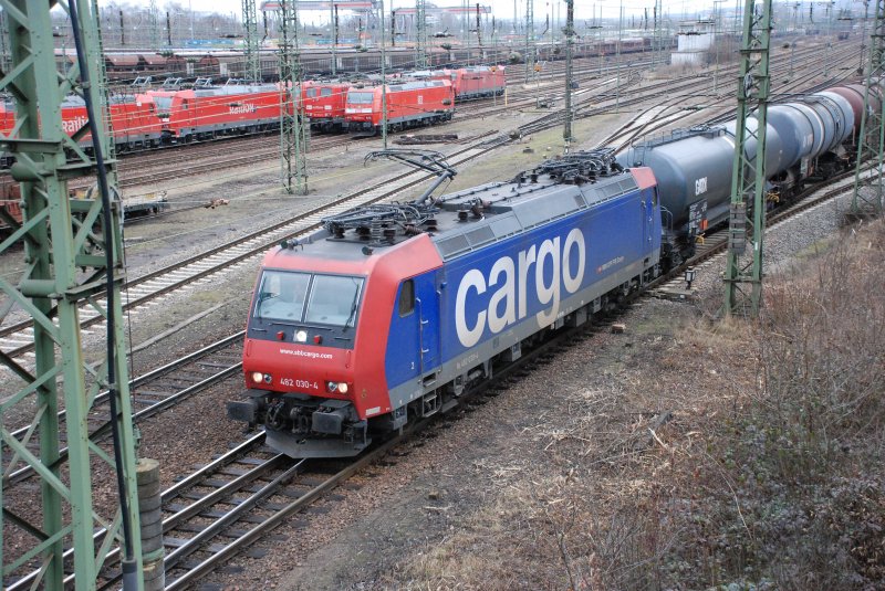 482 030-4 bei der Ausfahrt mit einem Kesselwagenzug in Richtung Basel aus dem Karlsruher Gbf am 23.02.2009. Im Hintergrund ist ein grosser Teil der abgestellten Loks des BW Karlsruhe zu sehen.
