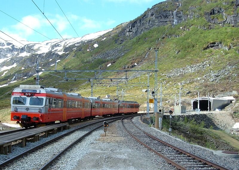 69 669 am 14.06.2006 im Bahnhof Myrdal, im Hintergrund die Einfahrt des 5311 Meter langen Gravhals-Tunnels (Richtung Voss - Bergen).