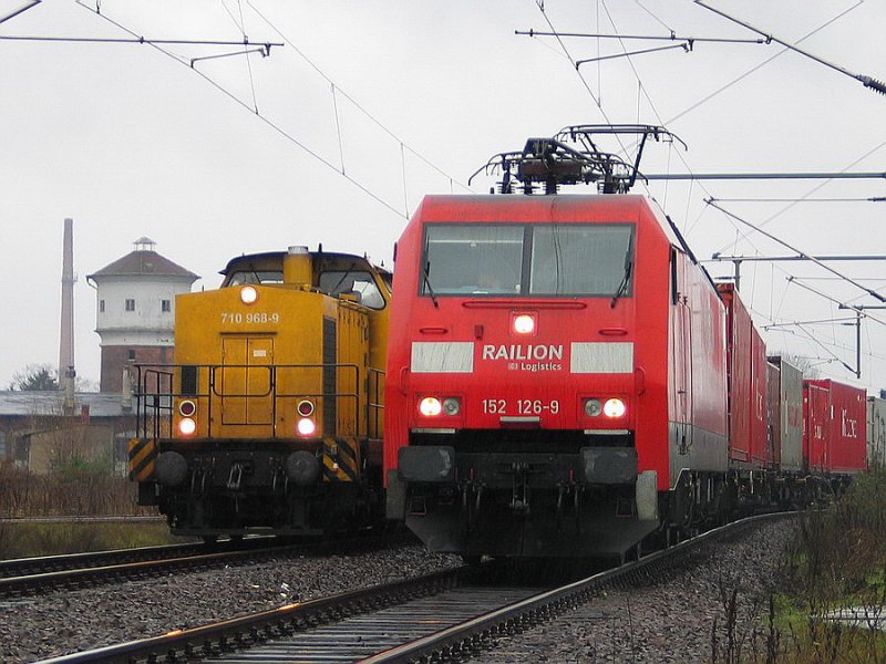 710 968 berholt den Gterzug mit 152 128 im Regen im Bf. Ludwigslust. Im Hintergrund der Wasserturm mit Lokschuppen 11/2006