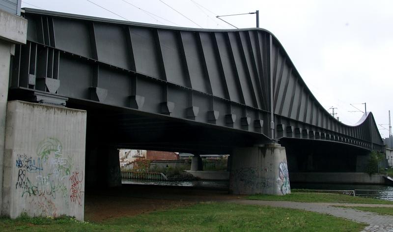 7gleisige Eisenbahnbrcke ber die Havel in Berlin-Spandau (2+2+3). Frher 51 m lang, fr Europaschiffe wren 80 m erforderlich gewesen, tatschlich ist sie 120 m lang gebaut worden.  Sie berbrckt auf beiden Seiten noch 20 m Wiese!!! Da sie eine Kragtrgerbrcke ist, mu sie durch Rckverankerungen gegen Abheben besonders gesichert werden. Vermutlich die  dmmste  Eisenbahnbrcke berhaupt. Schn ist sie dennoch. Zumeist baut man aber Eisenbahnbrcken als Fachwerk- oder Stabbogenbrcken. Die Edelstahlrckverankerungen wurden nachtrglich mit Beton umbaut (im Bild ganz links der hliche Klotz. Sichtschutz?).