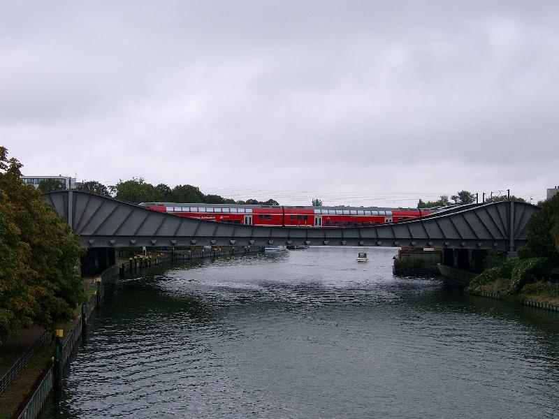 7gleisige Eisenbahnbrcke ber die Havel in Berlin-Spandau mit einem RE 160. Hier der Blick von der Dischinger Brcke aus. Eine ziemlich kostspielige Brcke, weil sie nicht eisenbahntypisch als Stabbogen oder Fachwerk gebaut wurde, sondern als Kragtrger. Sie neigt deshalb beim Befahren zum Abheben an ihren Enden und mute zustzlich mit Edelstahlankern rckverankert werden. Mehrkosten  8 Millionen DM!!! Sie ist als sogenannte  Innovative Brcke  fr Spandau errichtet worden. Die zustzlichen Kosten haben sich  Berlin und die Bahn geteilt.