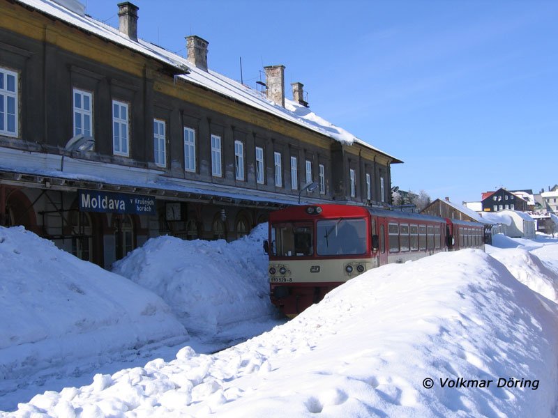 810 529 mit 810 039 im tief verschneiten Bhf Moldava (Moldau im Erzgebirge); für die Fahrgäste wurde ein schmaler Zugang zwischen Bahnhof und Triebwagen freigeschaufelt - 24.02.2006
