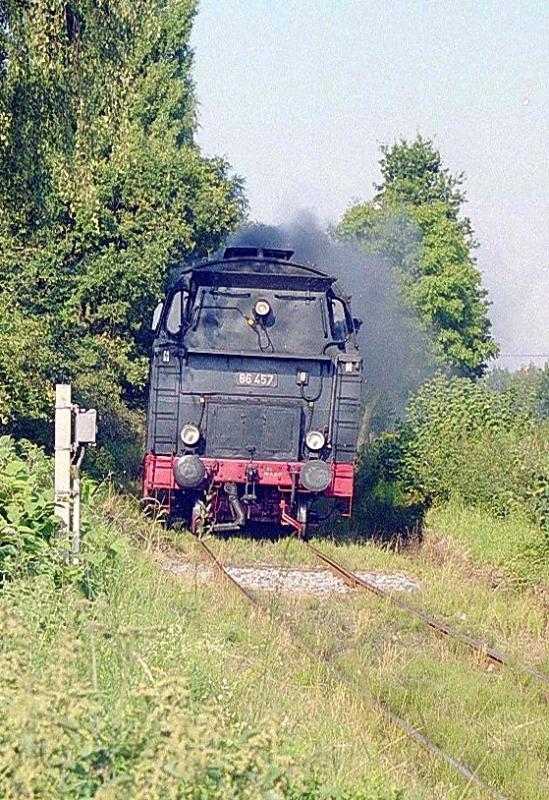 86 457 bringt ihren Zug von Schnberg-Strand nach Kiel.
Sekunden spter wird sie die Landstr. zwischen Muxall und Schnkirchen berqueren.

Sommer 2000