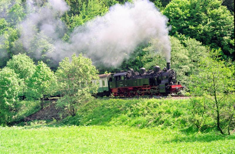 94 1292 hat soeben den  Knick  erreicht, die Stelle, an der die Steigung auf der Strecke Sttzerbach--Bf. Rennsteig so richtig in die vollen geht. Es ist immer wieder faszinierend, wie sich hier an der kleinen Brcke ber die noch junge Ilm, der Auspuffschlag abrupt verlangsamt ...
Frhling 2003 -- Minolta CLE/Leitz Tele-Elmarit-M 2,8/90 mm -- Fuji Reala