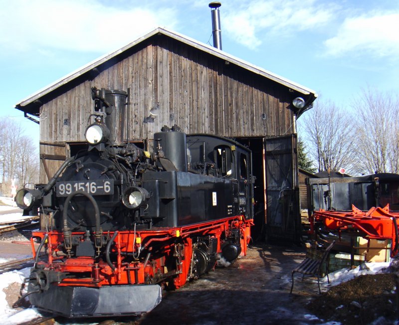 99 1516-6 vor dem Lokschuppen in Schnheide-Mitte. Auf dem Dach glnzt der neue Rauchabzug des vorderen Dampflokstandes, 07.02.2009