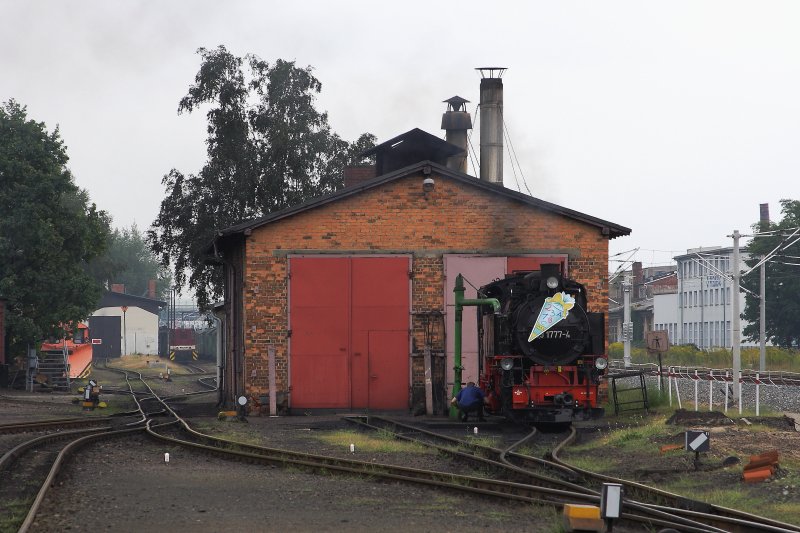 99 1777 am Nachmittag des 31.08.2012 im Bw Radebeul-Ost. Whrend die Lok Wasser fat, werden vom Personal Wartungsarbeiten durchgefhrt. Links im Bild sind die fr eine historische Schmalspurbahn doch recht umfangreichen Gleisanlagen im hinteren Bw-Bereich und rechts die erst krzlich ertchtigten Gleisanlagen der Hauptstrecke Dresden-Leipzig zu sehen.