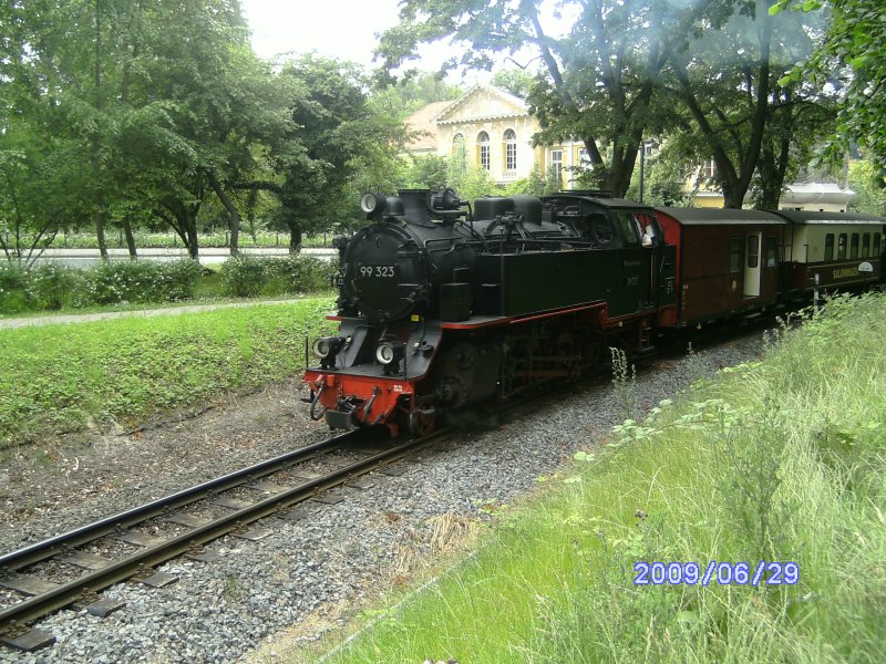 99 323 ist am 29.Juni 2009 mit ihrem Personenzug am Kilometer 0,1 auf Bergfahrt in Bad Doberan.