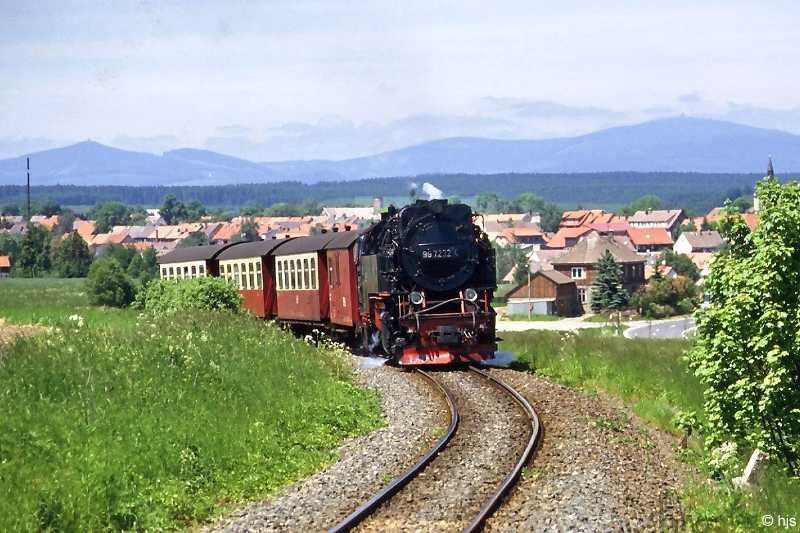 99 7232 schnauft die Steigung von Hasselfelde her herauf (16. Juni 1996). Im Hintergrund der Brocken (rechts) und der Wurmberg (links).
