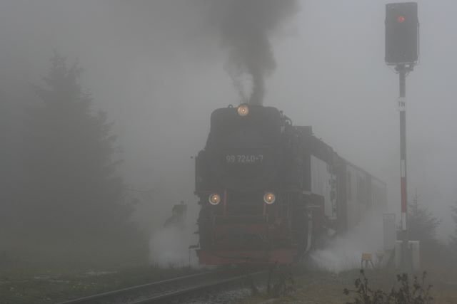 99 7240 passiert an einem nebligen Herbsttag auf dem Weg zum Brocken das Rckdrckgleis am Goetheweg. Die Fahrdienstleiterin das talfahrenden Zuges bedient Weiche und Signalanlage um den ausweichenden Zug wieder auf die Strecke und weiter nach Schierke zu leiten; 04.10.2007