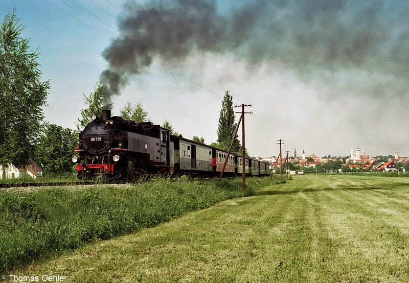 99 735 mit Personenzug im Mai 2005 zwischen Bf Zittau/Vorstadt und Hp Olbersdorf/Niederdorf, im Hintergrund die Stadtkulisse von Zittau.