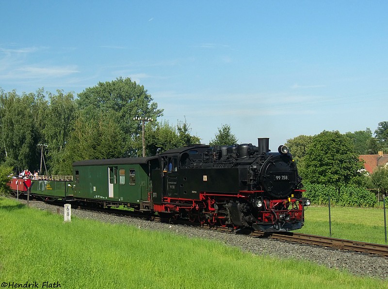 99 758 bringt am 02.08.2009 den immernoch gut besetzten Aussichtswagenzug weiter in Richtung Bertsdorf. Aufgenommen in der Ortslage von Olbersdorf.