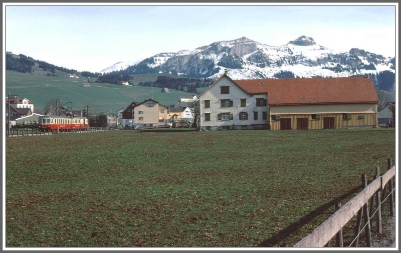 AB Pendelzug bei Schwende mit einem typischen Appenzeller Bauernhaus (Rckseite oder Wetterseite) und dem Hohen Kasten im Hintergrund. (Archiv H.Graf April 1977)
