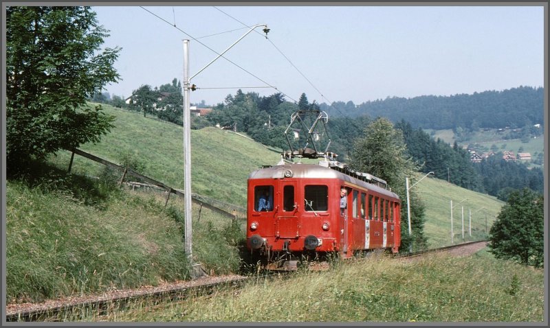 ABDeh 2/4 24 der RHB unterhalb Heiden. Der Triebwagen trgt noch die Jubilumsplakate auf der Seite  100 Jahre RHB , wurde die Bahn im Appenzeller Vorderland doch 1875 gegrndet. Der Lokfhrer, der so interessiert aus dem Seitenfenster schaut, ist mein Vater. (Archiv 07/75)