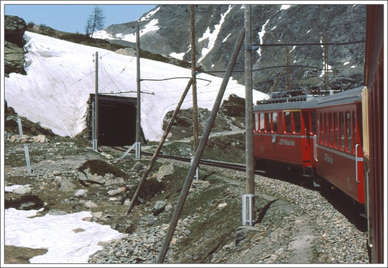 ABe 4/4 35 kmpft sich immer noch bergauf oberhalb Alp Grm. Nach passieren der letzten Lawinengalerie wird der Zug den Lago Bianco und damit die Passhhe beinahe erreicht haben. (Archiv 06/83)