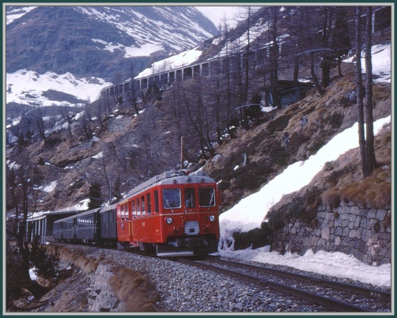 ABe 4/4 49 nhert sich von Poschiavo kommend der Station Alp Grm. (Archiv 04/78) Erst der Triebwagen ist rot, der zweiachsige D, die zwei B und der AB sind noch im ehemaligen RhB-Grn unterwegs. Oberhalb des Zuges erkennt man die Weiterfhrung der Strecke nach der Station Alp Grm in einer langen Lawinengalerie.