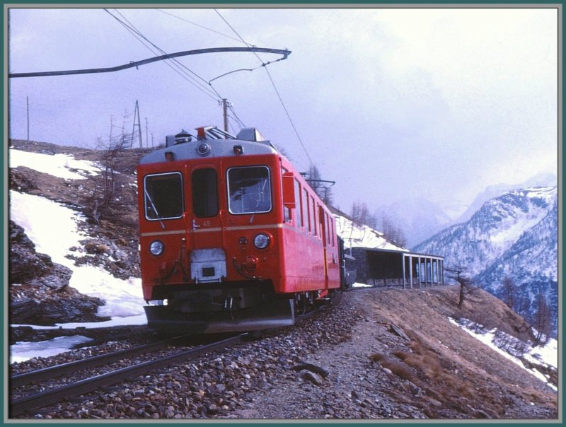 ABe 4/4 49 verlsst die Lawinengalerie oberhalb der Station Alp Grm. Frher war es bei einzelnen Zgen durchaus blich, dass in Alp Grm eine Kaffeepause eingeschaltet wurde, weshalb es mir auch mglich war den gleichen Zug unter- und oberhalb Alp Grm zu fotografieren. (Archiv 04/78)