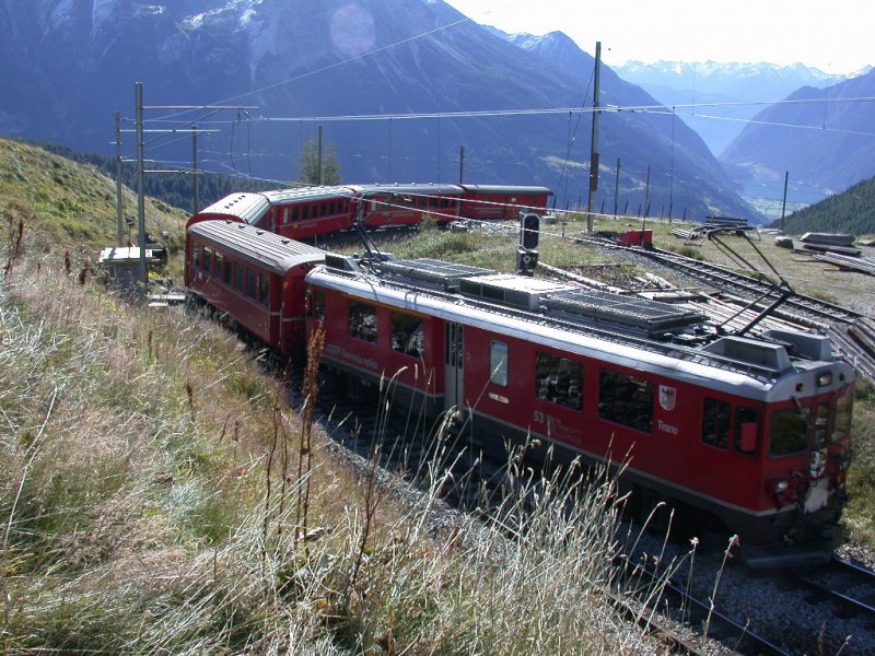 ABe 4/4 53  Tirano  erreicht mit einem Regionalzug die Station Alp Grm. Im Hintergrund der Puschlaversee und die Berge im italienischen Veltlin. (18.09.2001)