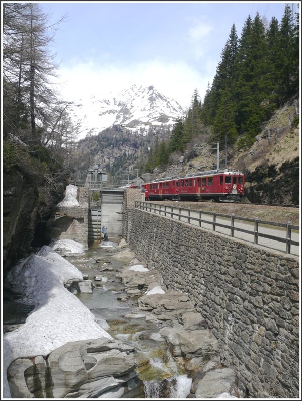 ABe 4/4 II 42 und ein baugleicher Triebwagen fhren den BerninaExpress 953 talwrts. Vor der Kulisse des Sassal Mason 3031m verlsst der Zug soeben die Hochebene von Cavaglia und windet sich jetzt ber unzhlige Kehren auf der 70 o/oo Strecke 700m in die Tiefe bis zur nchsten Ebene bei Poschiavo. (06.05.2009)